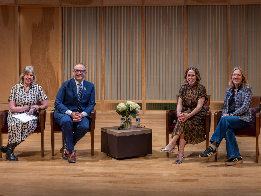 Shirley Stephenson with Charles Yingling, Stephanie Gibson and Katherine Fusco on stage, sitting on chairs, smiling.