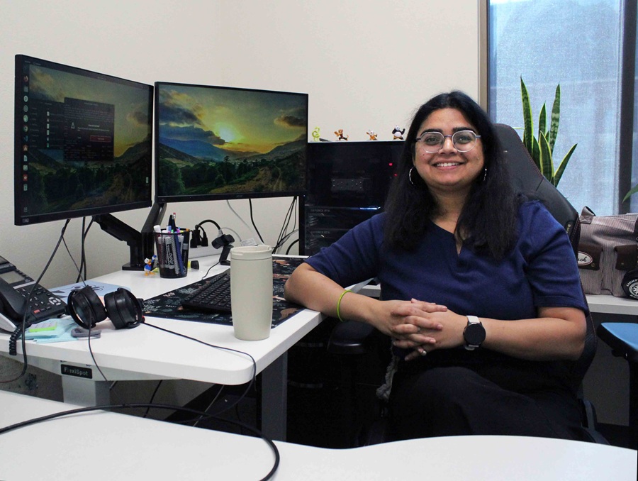 Woman sitting at a desk, smiling.