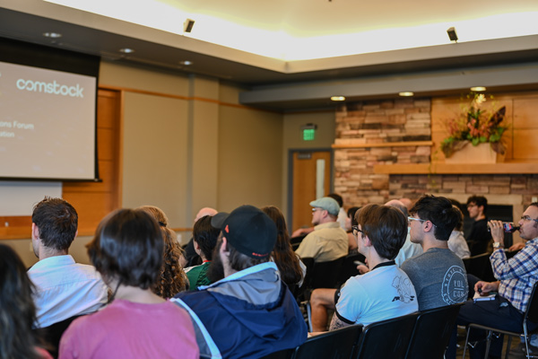 People seated in rows watching a presentation.