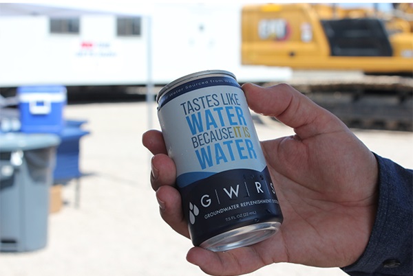An aluminum can that reads "Tastes like water because it is water," in someone's hand.