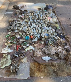 A large pile of litter on the dirt.