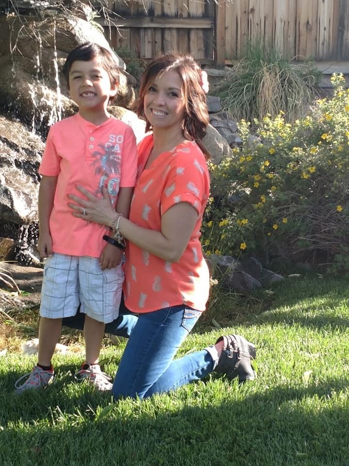 Erin Hess and her son pose smiling outside.