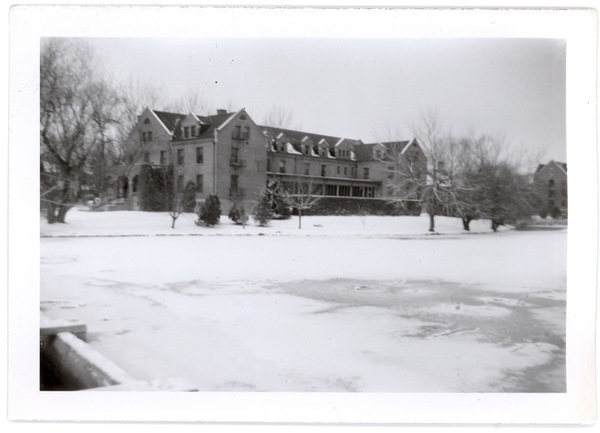 Historical black and white image of Manzanita Lake frozen over with Manzanita Hall in the background.