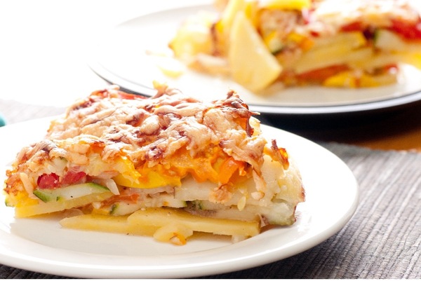 Cheesy potato casserole slice on a plate.
