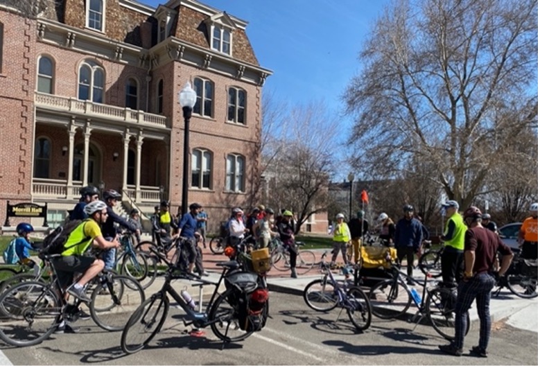 A group of about 15 people stand in helmets next to their bicycles outside near Morrill Hall on campus at the University of Nevada, Reno on a clear day.