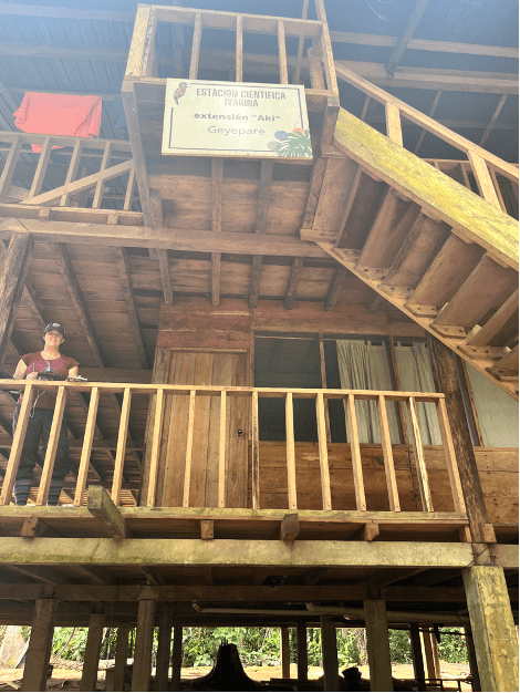 A large yellow field station that looks like it's a few stories high and Dr. Richards standing on a balcony.