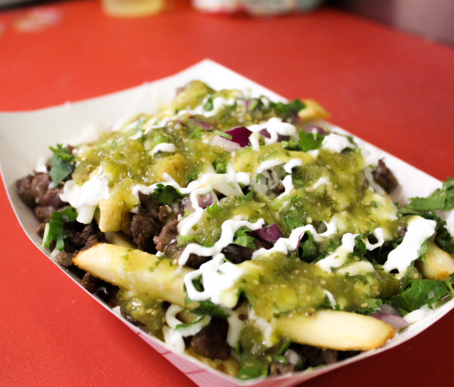 Carne asada fries with green salsa and sour cream.