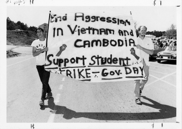 Two students carrying a protest sign.