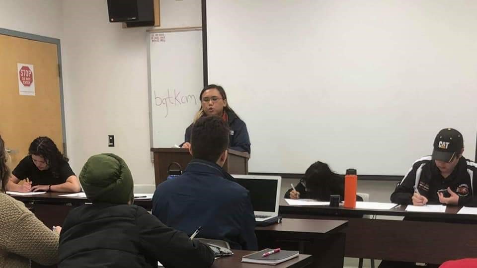 John Villanueva at the debate semi-finals speaking in front of an audience in a classroom