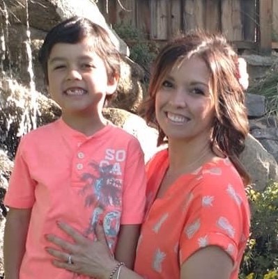 Erin Hess and her son both outside smiling wearing orange shirts. 