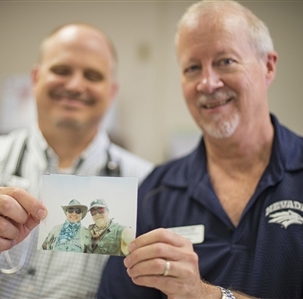 Dr. Gary Johnson with colleague holding photo of them at Burning Man