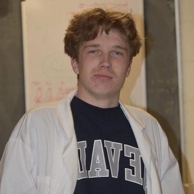 Jaden Tedsen smiling in front of a research poster.