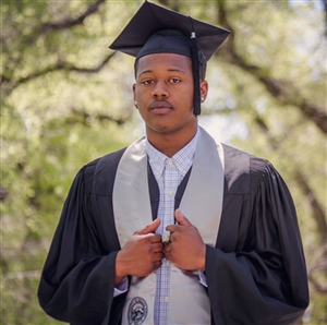 Ricky Thomas Jr in cap and gown on the Quad