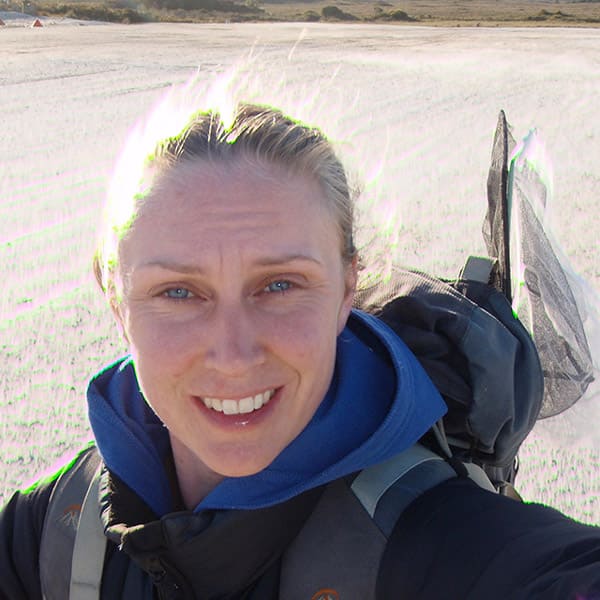 Jamie Voyles in the field with a net sticking out of her backpack