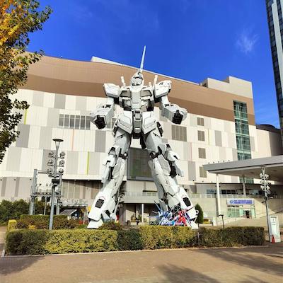 A large robot in a courtyard. The robot is almost as large as a three-story building.