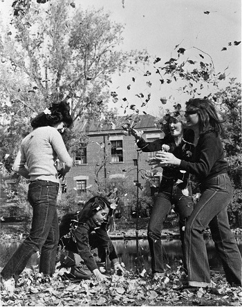 Female sorority members playing with leaves on campus