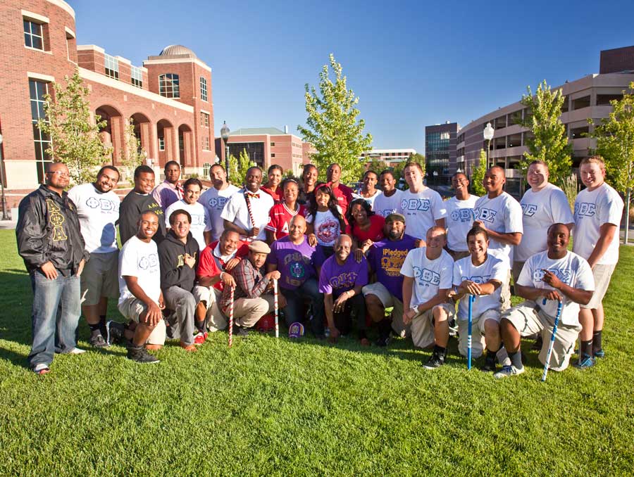 Members of various fraternities and sororities, including black fraternitities and sororities, pose on the lawn in front of the Knowledge Center