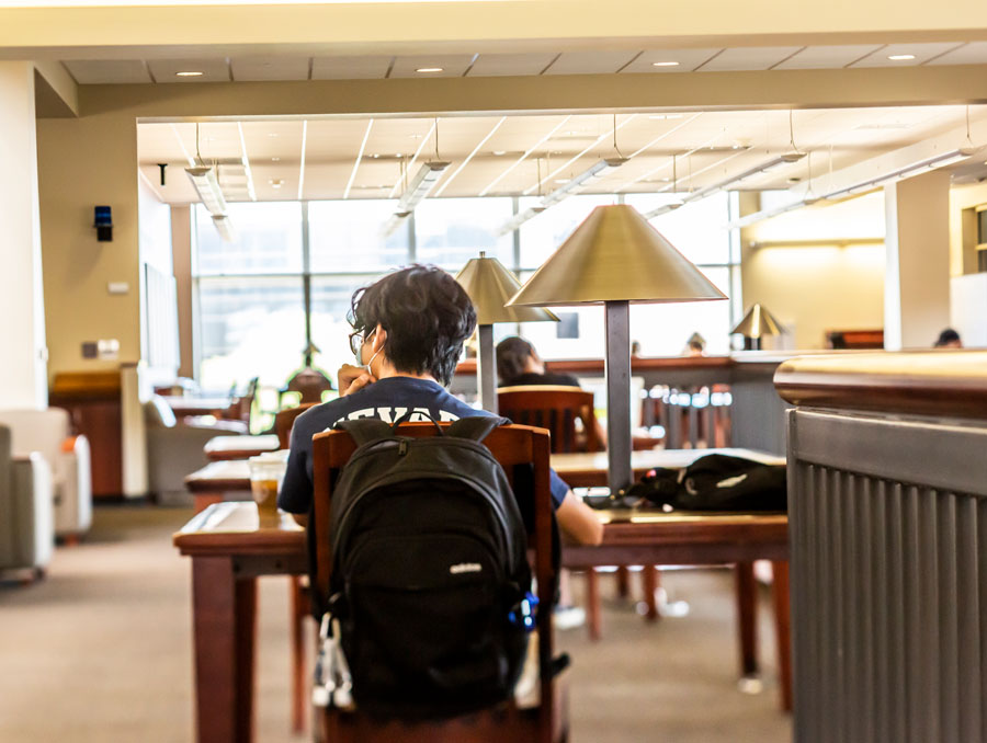 A student studying at a table in the library