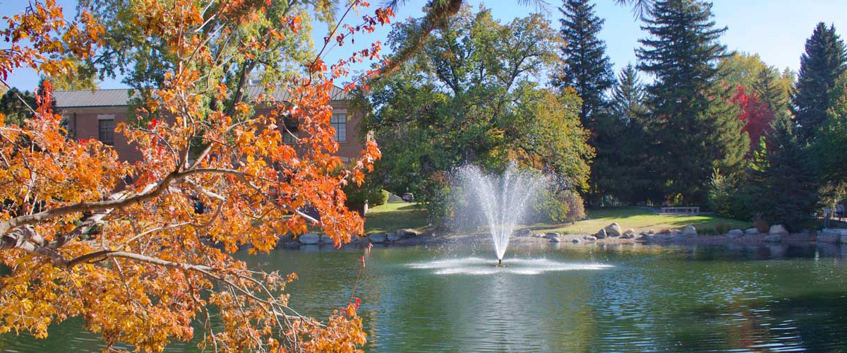 Manzanita Lake with the fountain spraying a burst of water and fall foliage in the foreground