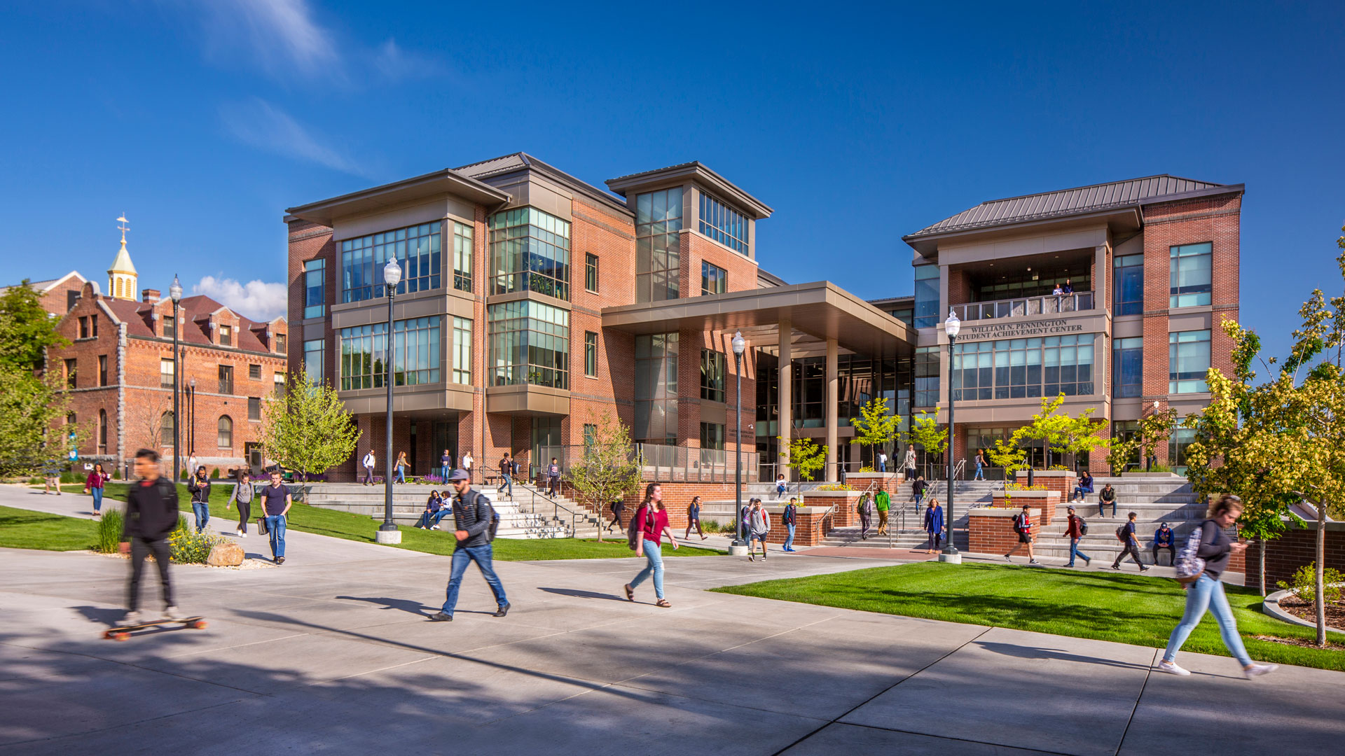 Students walk, ride skateboards and hang out in front of the Pennington Student Achievement Center at the University of Nevada, Reno.