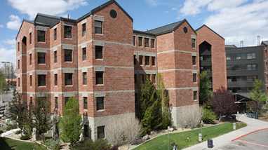 Exterior of Canada Hall, a modern multi-story brick residence halls with grass landscaping on the campus of the University of Nevada, Reno.