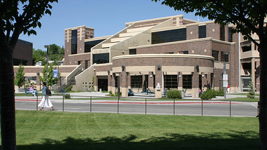 Exterior of Fitzgerald Student Services building, a multi-story brick building with grass landscaping, a large stair entryway and walking paths.