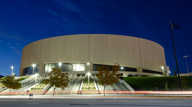 An exterior view of Lawlor Events Center, a large, round multipurpose events facility with large windows and concrete steps rising up in front of the building.