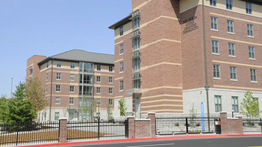 Exterior of the Nevada Living Learning Community, a modern brick building residence hall, on the campus of the University of Nevada, Reno.